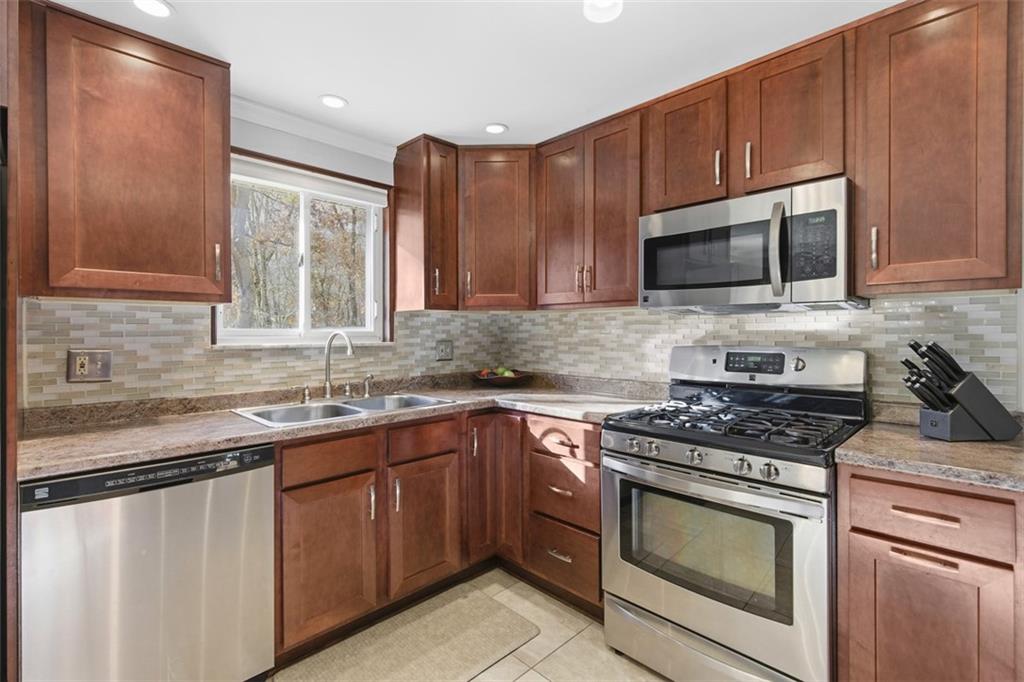 301 Amity Road Glenshaw, PA 15116 - Photo 7 of 30 a kitchen with granite countertop wooden cabinets stainless steel appliances and a sink