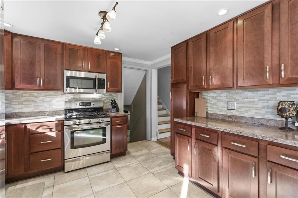 301 Amity Road Glenshaw, PA 15116 - Photo 8 of 30 a kitchen with stainless steel appliances granite countertop wooden cabinets a stove top oven a sink and dishwasher