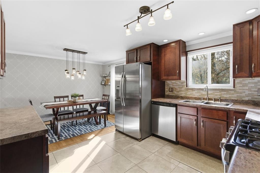 301 Amity Road Glenshaw, PA 15116 - Photo 9 of 30 a kitchen with stainless steel appliances granite countertop a table chairs and a refrigerator