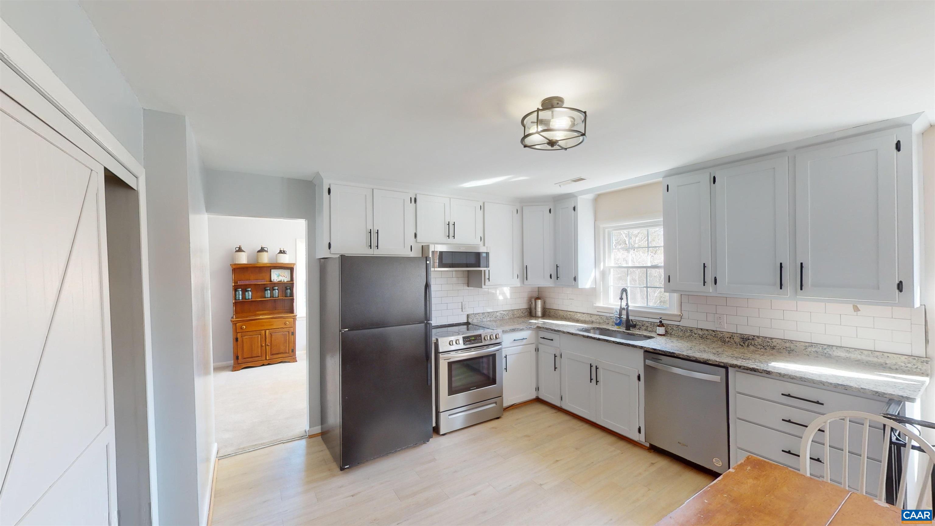 206 Georgetown Road Charlottesville, VA 22901 - Photo 4 of 35 a kitchen with stainless steel appliances granite countertop a refrigerator a sink a stove and white cabinets
