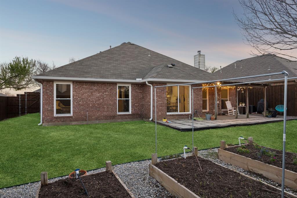 12404 Ark Road Frisco, TX 75035 - Photo 26 of 28 a front view of a house with garden and wooden fence