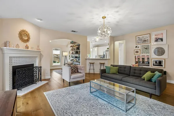 a living room with furniture a chandelier and a fireplace