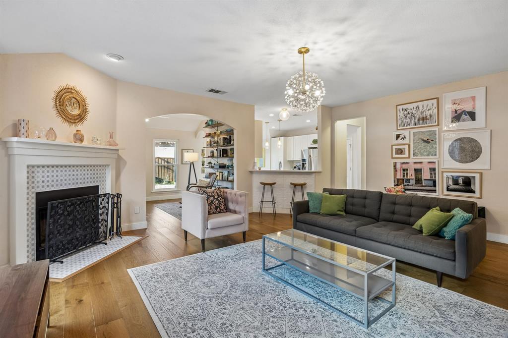 12404 Ark Road Frisco, TX 75035 - Photo 3 of 28 a living room with furniture a chandelier and a fireplace
