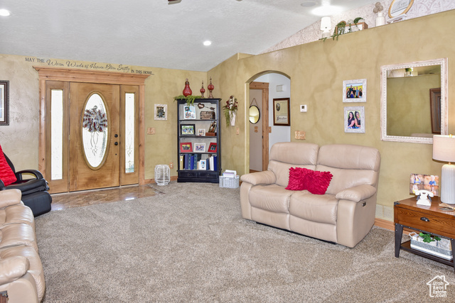 1500 Fish Creek Road Bancroft, ID 83217 - Photo 15 of 45 Living room with vaulted ceiling, arched walkways, and carpet flooring