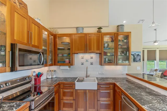 a kitchen with stainless steel appliances granite countertop a sink stove and cabinets