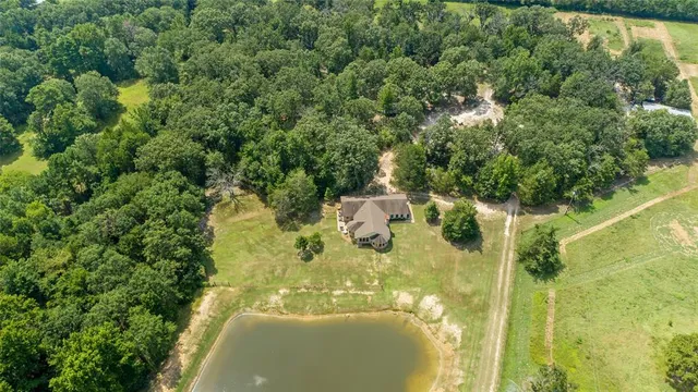 an aerial view of residential houses with outdoor space and trees