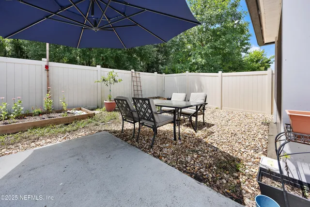 a backyard of a house with table and chairs