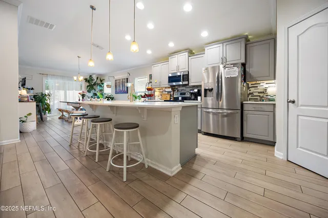 a kitchen with stainless steel appliances a refrigerator a stove top oven and a center island