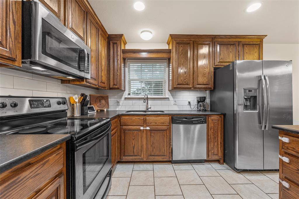 109 Ruby Circle Hewitt, TX 76643 - Photo 6 of 14 a kitchen with stainless steel appliances granite countertop a stove microwave and refrigerator