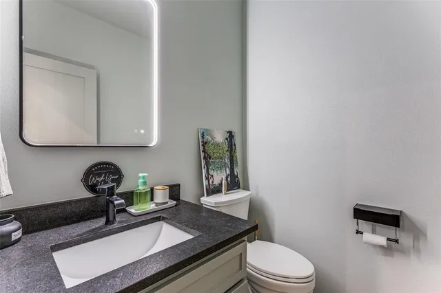 a bathroom with a toilet a sink and mirror