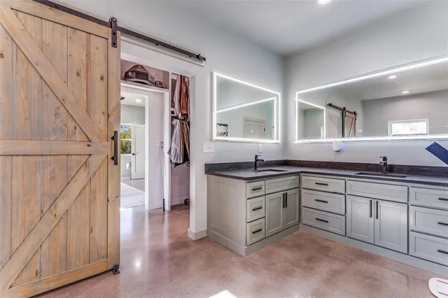 a spacious bathroom with a granite countertop sink a mirror and a vanity