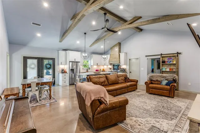 a living room with furniture kitchen view and a wooden floor