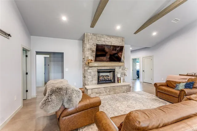 a living room with furniture a flat screen tv and a fireplace