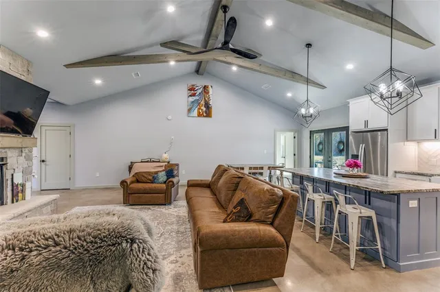 a living room with furniture a flat screen tv and a chandelier