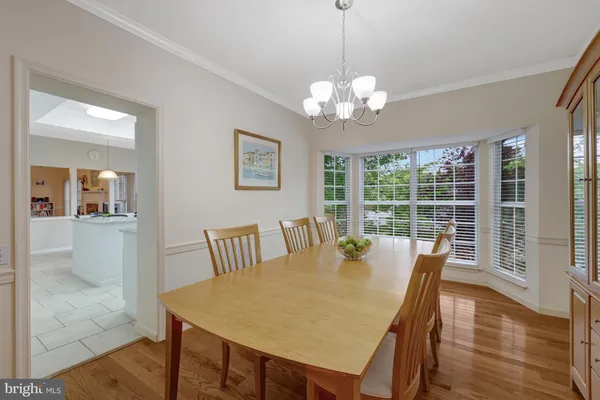 a view of a dining room and livingroom with furniture wooden floor and a chandelier