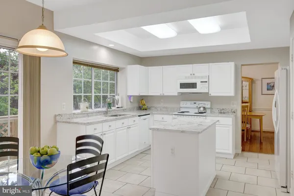 a kitchen with stainless steel appliances granite countertop a stove a refrigerator and a dining table with wooden floor