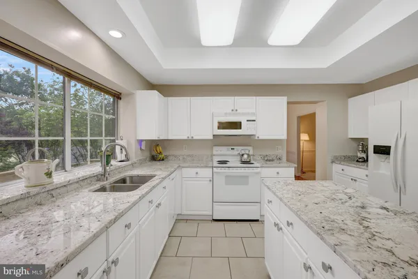 a kitchen with stainless steel appliances granite countertop a sink and cabinets