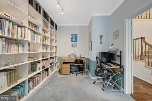 a view of a workspace with furniture and a window