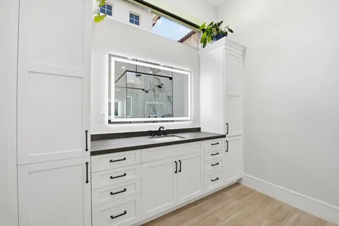a bathroom with a granite countertop shower sink vanity and mirror