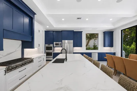 a kitchen with kitchen island granite countertop wooden cabinets and white appliances