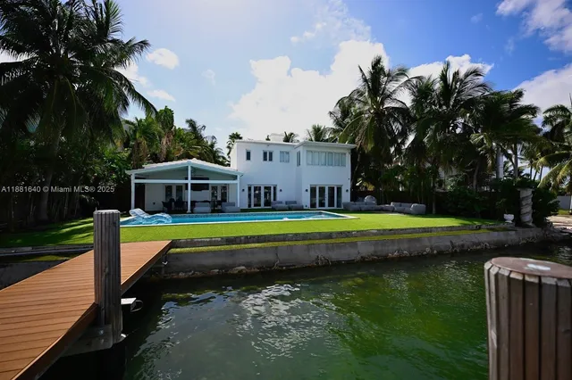 a view of a house with swimming pool and a yard