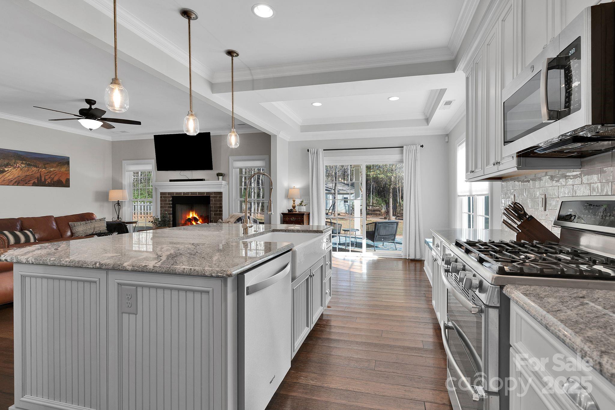 481 Evergreen Road Lake Wylie, SC 29710 - Photo 18 of 45 a kitchen with stainless steel appliances granite countertop a stove top oven a sink dishwasher a dining table and chairs with wooden floor