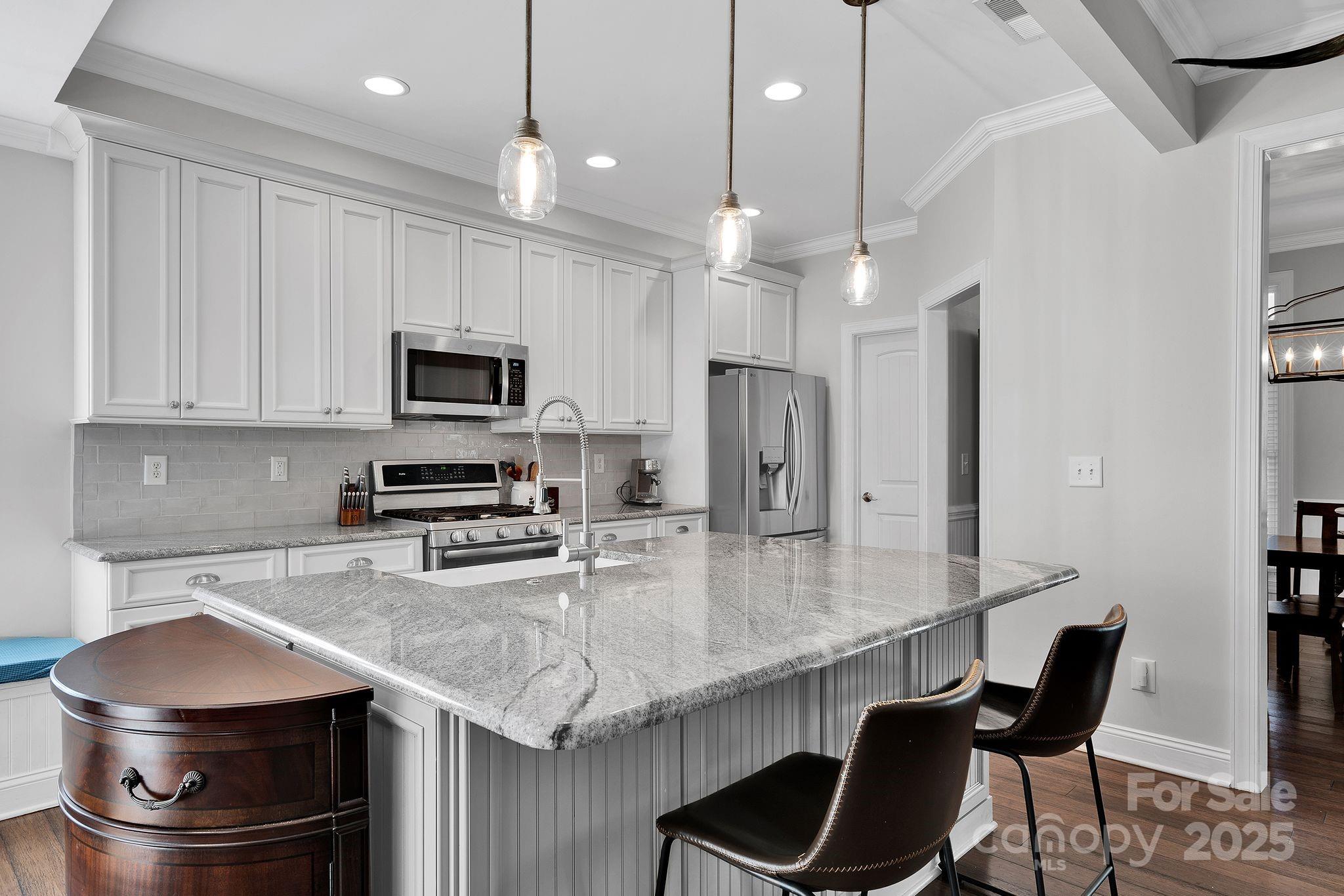 481 Evergreen Road Lake Wylie, SC 29710 - Photo 20 of 45 a kitchen with stainless steel appliances granite countertop a stove a refrigerator a sink a dining table and chairs with wooden floor