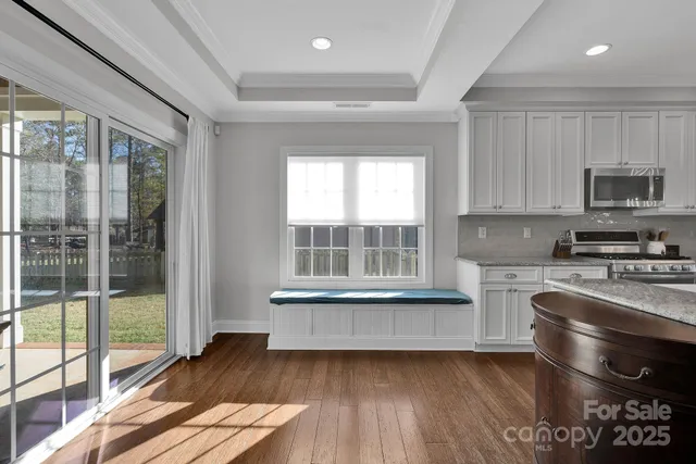 a kitchen with granite countertop a stove and a wooden floors