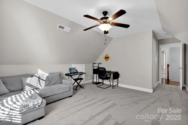 a living room with furniture and a ceiling fan