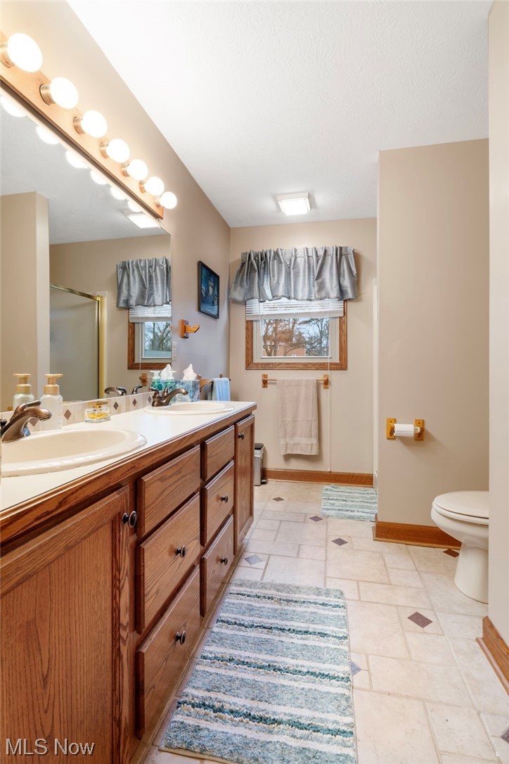 4915 Monticello Street Northwest Canton, OH 44708 - Photo 22 of 31 Master Bathroom with a double vanity, toilet, shower and tile flooring