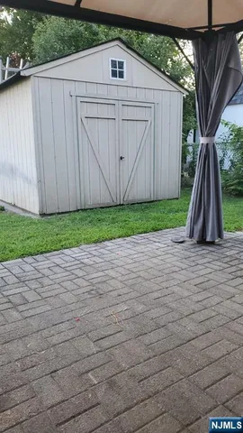 a view of backyard with small cabin and wooden fencing