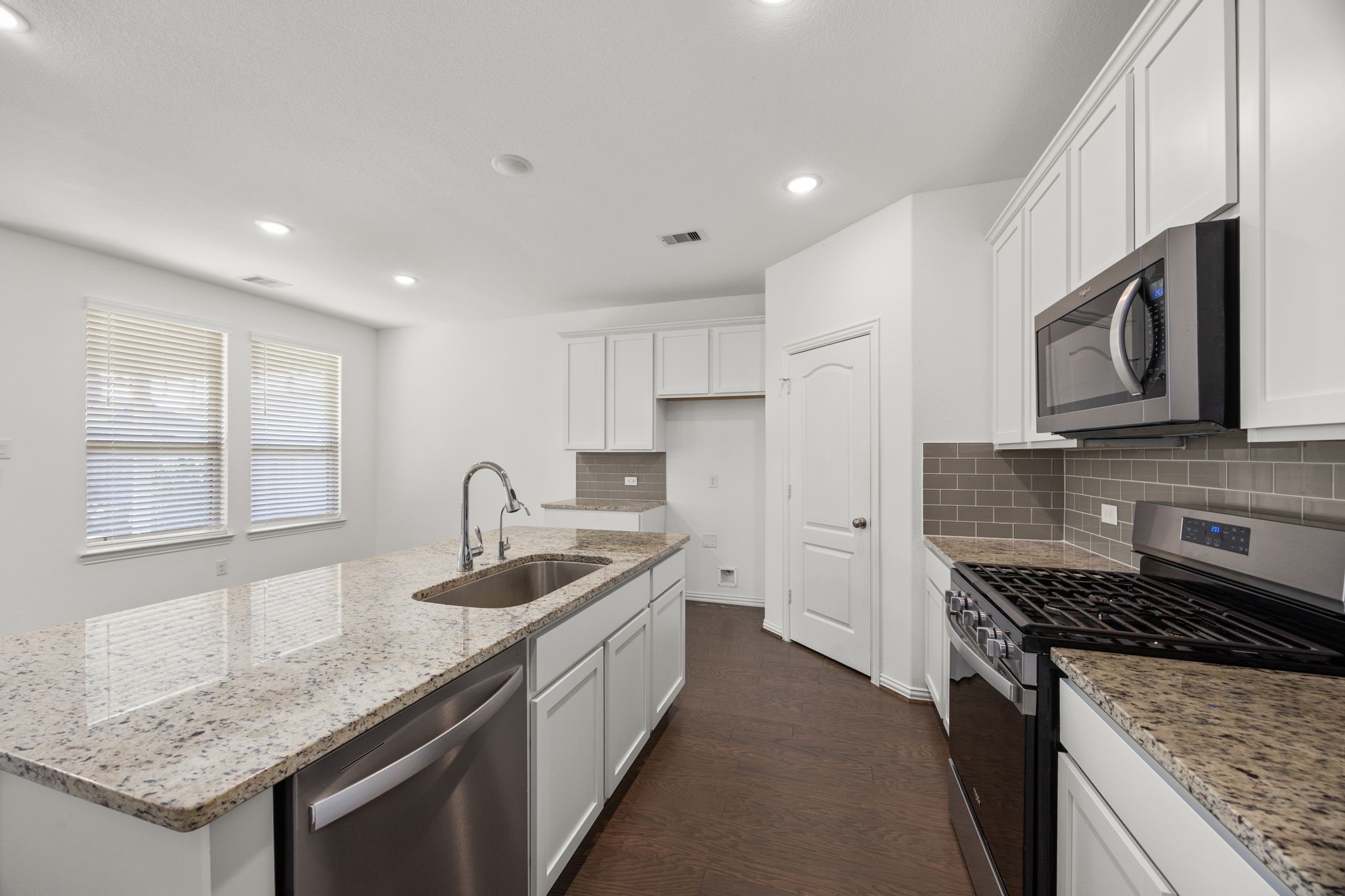 31319 Horseshoe Meadow Bend Lane Fulshear, TX 77441 - Photo 13 of 41 a kitchen with granite countertop sink stainless steel appliances and window