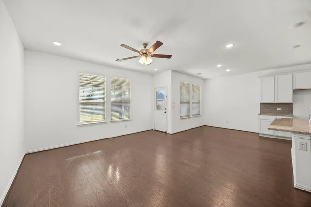 a living room with furniture kitchen view and a large window