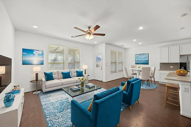 a view of kitchen with kitchen island stainless steel appliances refrigerator stove and white cabinets