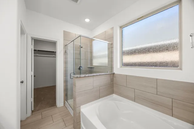 a bathroom with a granite countertop sink a mirror and a bathtub