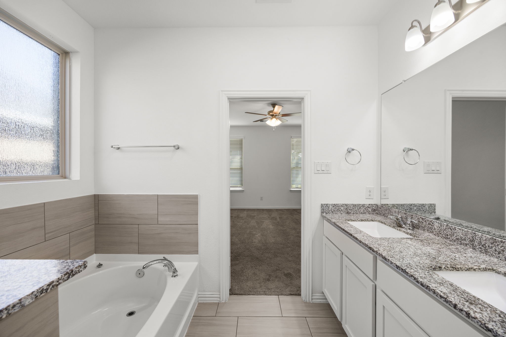 31319 Horseshoe Meadow Bend Lane Fulshear, TX 77441 - Photo 26 of 41 a bathroom with a granite countertop sink a mirror and a bathtub