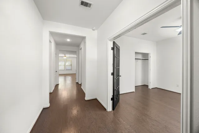 an empty room with wooden floor and a bathroom