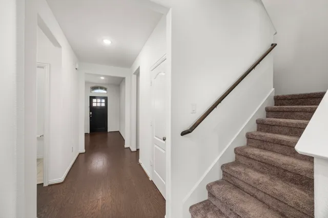a view of a hallway with wooden floor and entryway