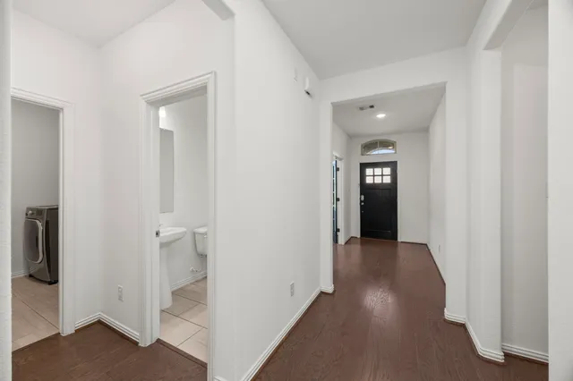 a view of a hallway with wooden floor and closet area