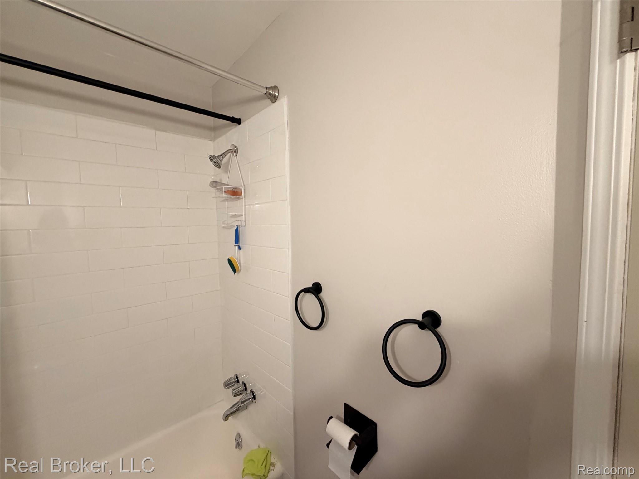 22444 Kelly Road, Unit 11 Eastpointe, MI 48021 - Photo 13 of 18 Bathtub with white subway tile surround, chrome fixtures, and matte black towel rings