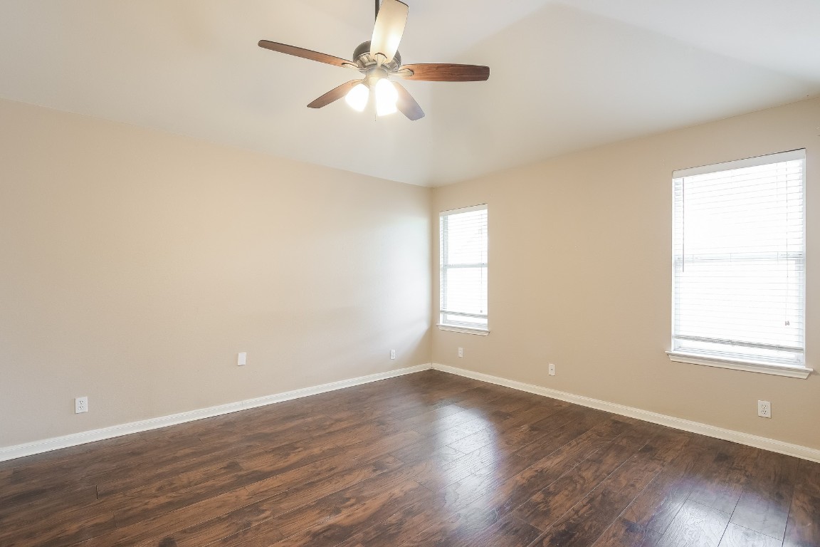 21304 Secretariat Ridge Lane Pflugerville, TX 78660 - Photo 13 of 29 an empty room with wooden floor fan and windows