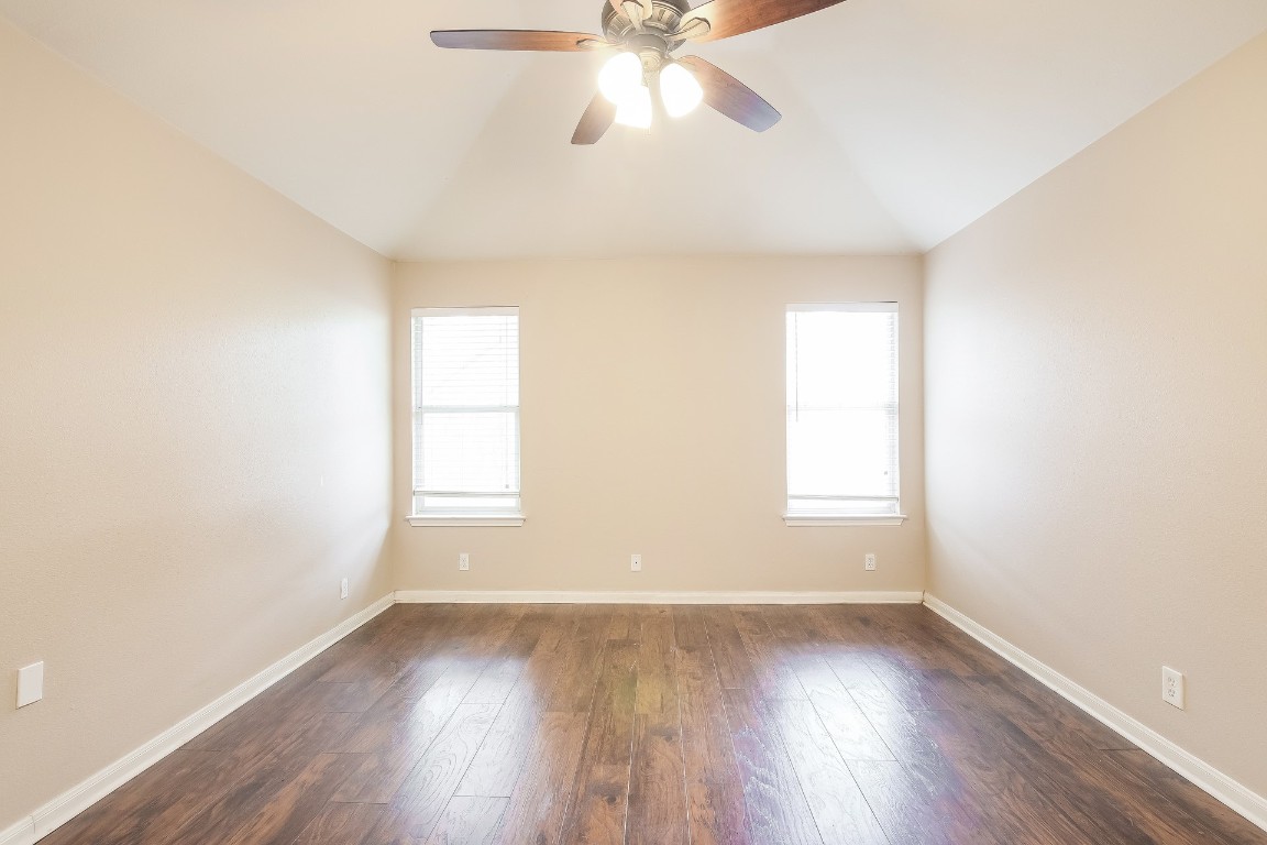 21304 Secretariat Ridge Lane Pflugerville, TX 78660 - Photo 14 of 29 an empty room with wooden floor and windows