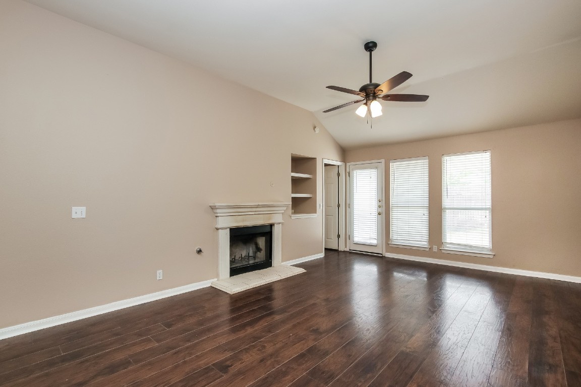 21304 Secretariat Ridge Lane Pflugerville, TX 78660 - Photo 3 of 29 a view of empty room with wooden floor fireplace and a window