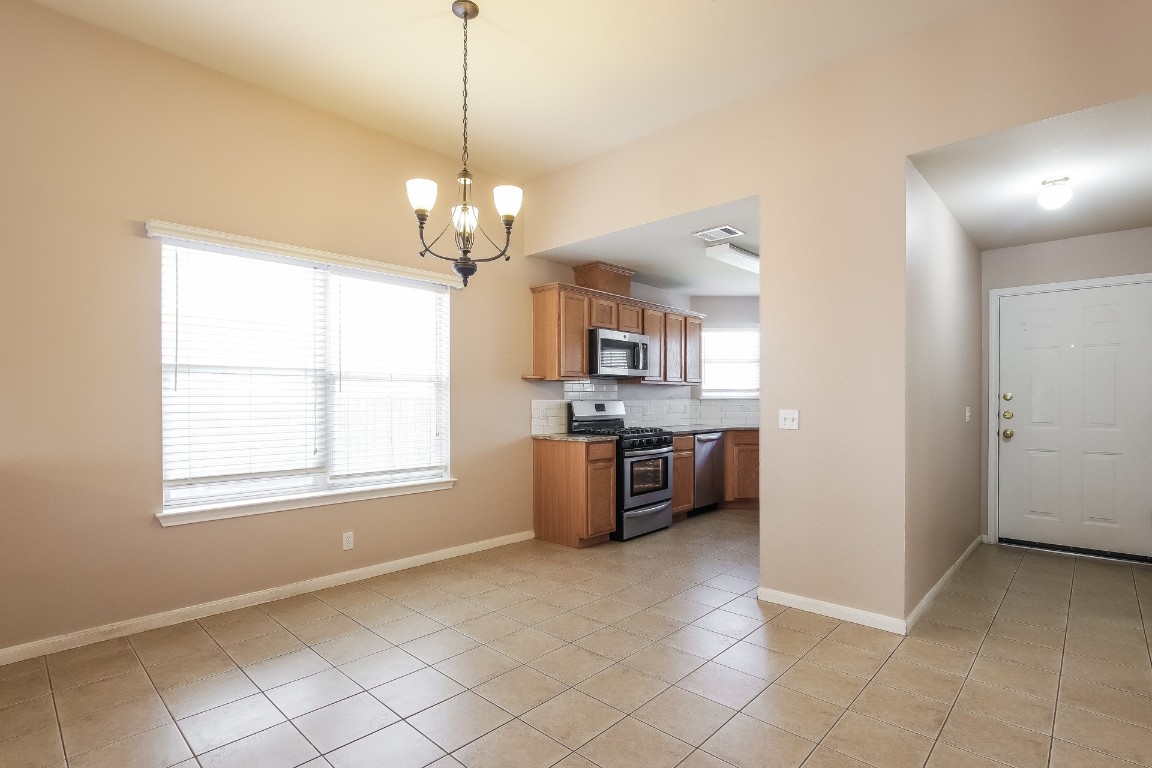 21304 Secretariat Ridge Lane Pflugerville, TX 78660 - Photo 6 of 29 a large kitchen with a stove a sink and dishwasher a refrigerator with wooden floor