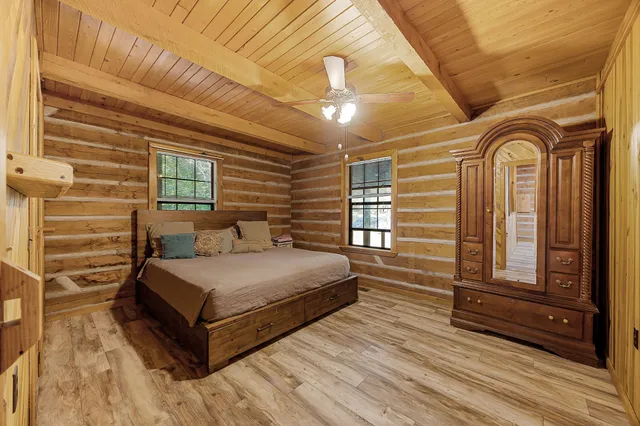 a spacious bedroom with a bed and wooden floor