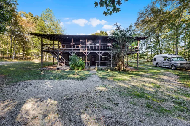a view of a park that has a sign board large trees