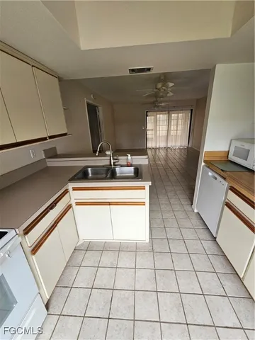 an empty room with a ceiling fan and carpet