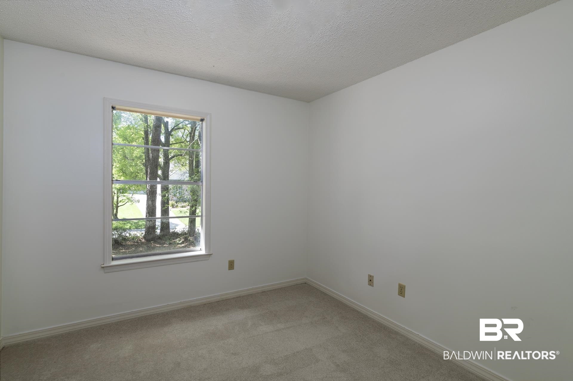 707 Johnson Avenue Fairhope, AL 36532 - Photo 27 of 38 Unfurnished room featuring baseboards, light carpet, and a textured ceiling
