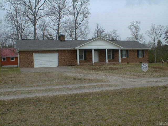 a front view of a house with yard and trees