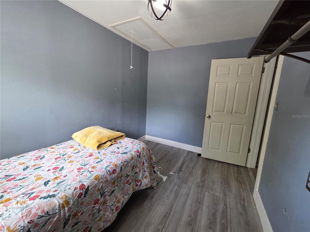 124 East F Street Frostproof, FL 33843 - Photo 22 of 37 a bedroom with a bed and wooden floor